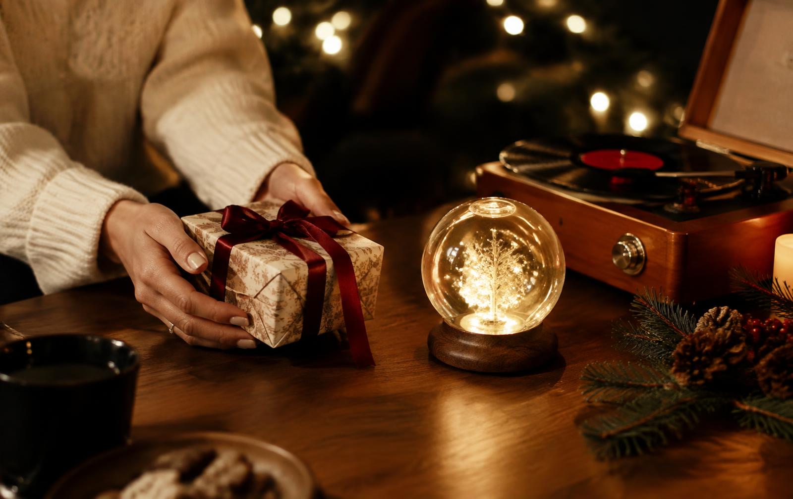 A Christmas gift beside a keepsake orb and record player